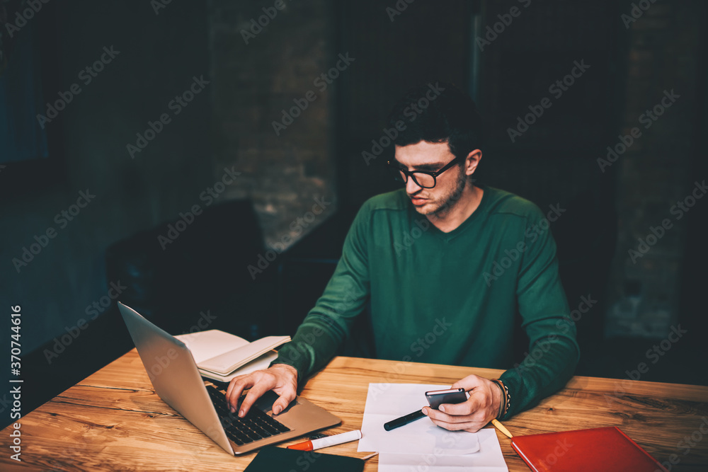 Aufkleber serious male graphic designer creating logotyp for company using laptop device and good internet con