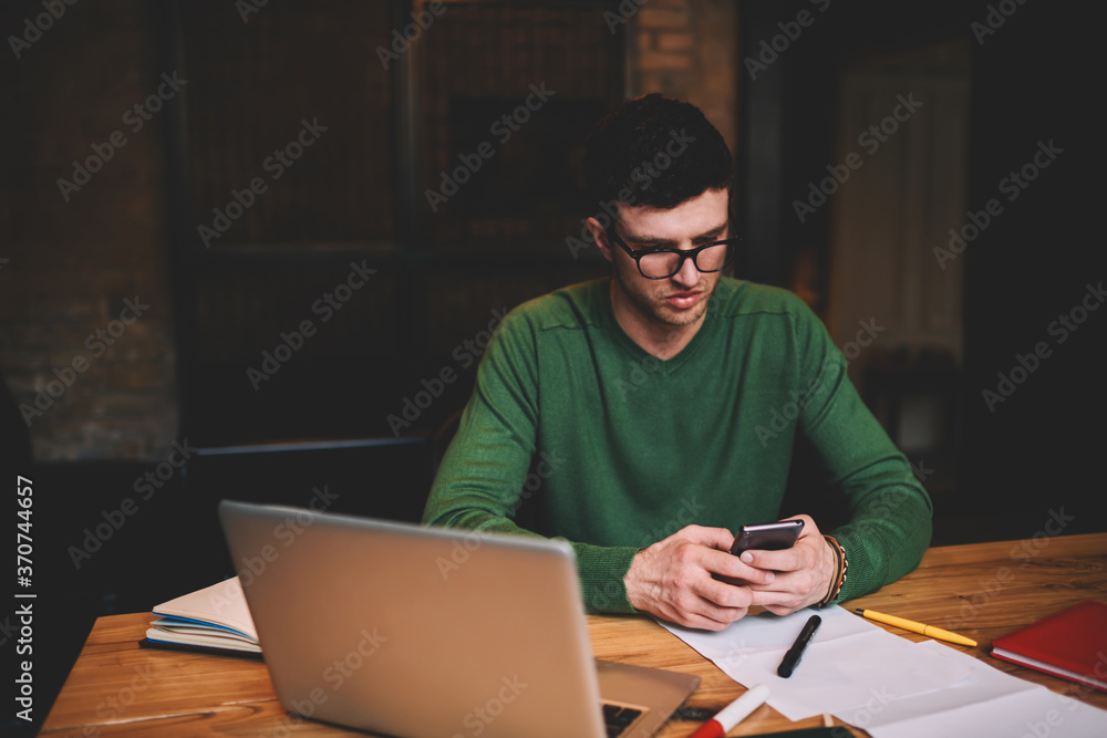 Poster young guy recreating during break in university sitting in campus with laptop computer