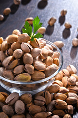 Composition with bowl of pistachio on wooden table. Delicacies