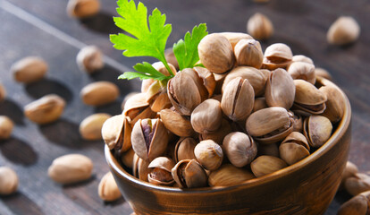 Composition with bowl of pistachio on wooden table. Delicacies