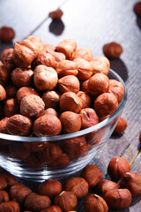 Bowl with hazelnuts on wooden table.