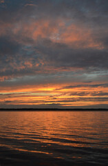 Spectacular lake sunset from Canada with multi-colours in the sky from pink, gold, orange and teal clouds.