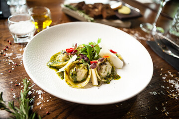 Black Angus hand-made dumplings. Cucumber-julienne with chilli-garlic butter or beef stock with sour cream. Delicious meat food closeup served on a table for lunch in modern cuisine gourmet restaurant