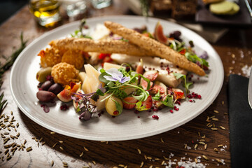 Cheese platter for two: Goat cheese cream, gorgonzola, camembert, grissini and fig jam. Delicious healthy Italian traditional food closeup served for lunch in modern gourmet cuisine restaurant