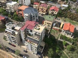Fototapeta premium Residential area in Tbilisi. Saburtalo District. Houses with colored roofs, top view. 10.08.2020. Georgia