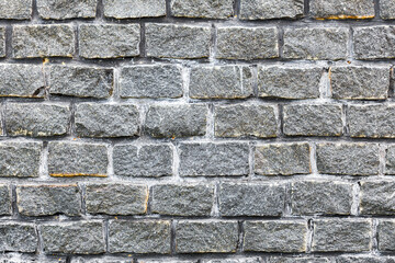 Abstract background of the old wall of black natural stone with cracks and scratches. Landscape style. Great background or texture.