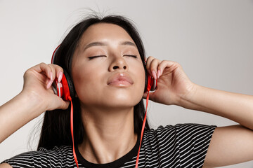 Young beautiful asian woman listening to music