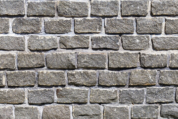 Abstract background of the old wall of black natural stone with cracks and scratches. Landscape style. Great background or texture.