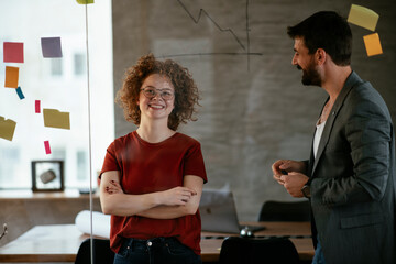 Colleagues in office. Businesswoman and businessman discussing work in office. Two friends in working together...