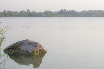 A large stone in the water on a lake in Siberia, Russia. Beautiful evening landscape