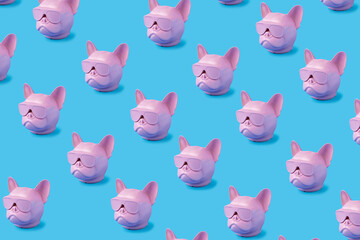 Pink French bulldog’s pattern made of head sculptures on a baby blue background. Minimalist photography concept. Isometric flat lay. Pop art inspired by Frenchie dog breed.