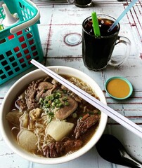 Beef broth and noodles (Ngiu Chap) with a cup of hot black coffee for breakfast