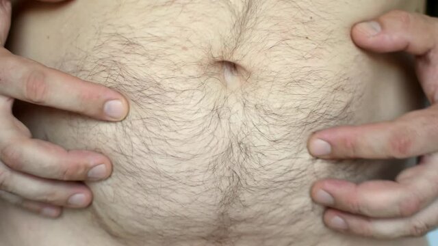 Fat belly of a man.The harm of overeating. Wrong food. Obesity.