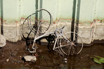 Altes, rostiges Fahrrad in einem Flussbett liegend