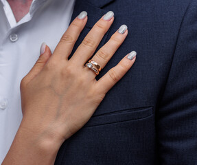 bride's hand with an elegant wedding ring with white gold diamonds on a bouquet of their peonies