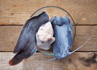 Fresh Catfish cut in pieces and placed in a bowl on a wooden table