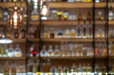 Defocused background of bar counter with various bottles of alcohol.