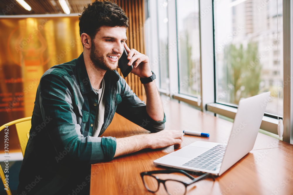 Poster good looking cheerful smart it programmer communicating with friends using cellular connected to 4g 