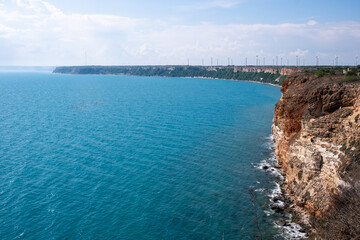 View Of The Sea From The Sea , High Red Ocean Cliff , Copy Space On The Water , Background with White Clouds and Blue Sky