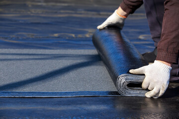 Worker puts roofing material