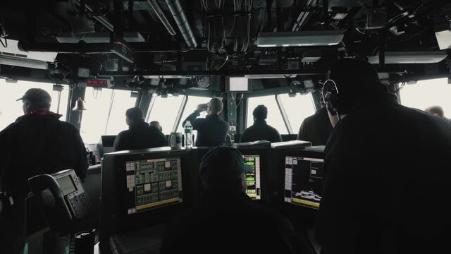 Crew working on navy ship bridge