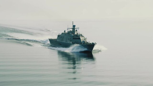 Drone shot of cruising navy ship, front