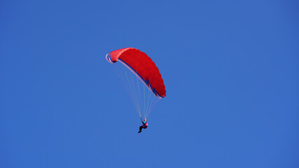 a paraglider on the blue sky