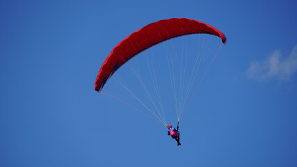 a paraglider on the blue sky