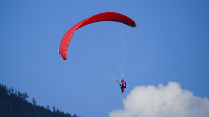 a paraglider on the blue sky