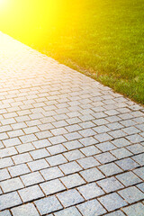 Stone walkway and green lawn in the park.