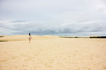 Fototapeta na wymiar young woman walking on the jericoacoara dunes