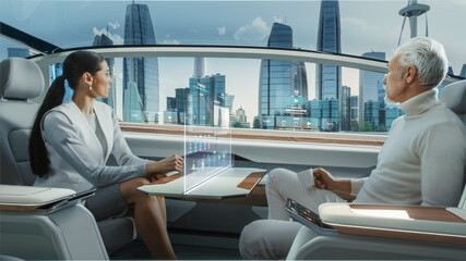 Casual Business Meeting Between Senior Male and Female inside a Futuristic Driverless Autonomous Car with Augmented Reality Presentation Interface. Self-Driving Van Driving on Downtown City Streets. 