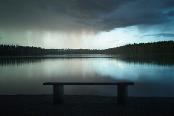 Rain cloud over a forest lake