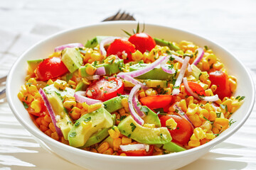 sweet corn salad with avocado in a bowl, close-up
