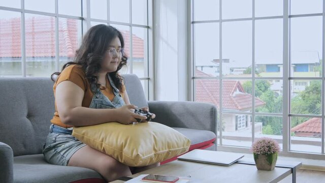 Fat woman playing games happily at home