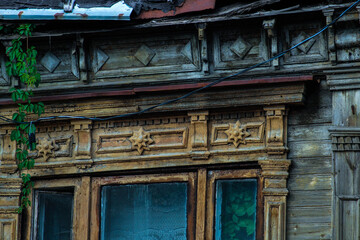 Fototapeta na wymiar Roof of an old Russian house. Carved roof of an old house. The carving on the tree. Beautiful handmade patterns