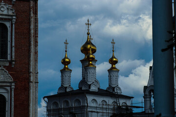 Beautiful temple with Golden domes on the background of storm clouds illuminated by the sun. The Church's landscape, the dome of the Orthodox Church