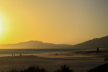 playa montañas dunas atardecer y mar