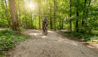 Man riding bicycle on forest road