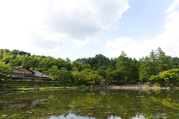 Fototapeta na wymiar HDR natural Japanese style decoration park and garden decorated greenery tree, Japanese style house and bush with its mirror reflection on clear water pond.