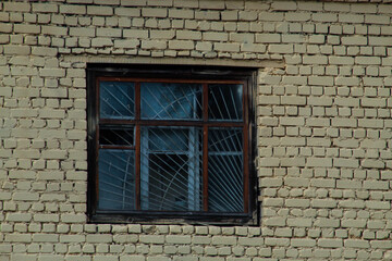 An old wooden window on an old yellow brick wall, a window with bars