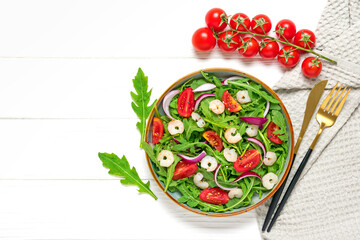 Mediterranean diet menu concept Healthy salad of fresh vegetables - tomatoes, arugula, purple onions, shrimps, soy sauce and sesame seeds in plate on white wooden table Vegan food Flat lay Top view
