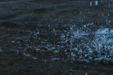 Beautiful bright splashes in the water. Water splashes from the fountain. Drops hitting the water