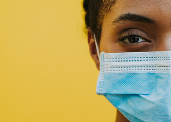 African american woman wearing medical mask - Powered by Adobe