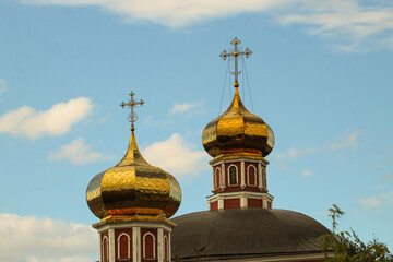 Golden Church domes in the blue sky. Russian church. Domes glisten in the sun