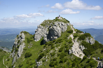 Velky Rozsutec, Mala Fatra, Slovakia. Unrecognizable tourists, hikers and trippers on the rocky top of the mountain and hill. People are doing tourism in sunny summer.