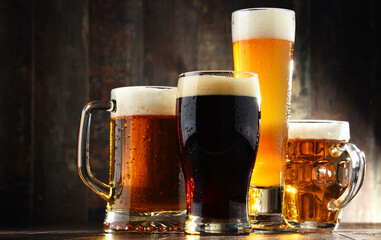 Four glasses of beer on wooden background