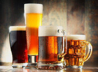 Four glasses of beer on wooden background