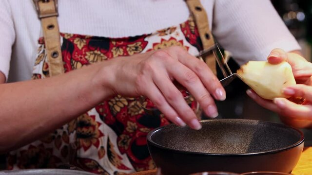 Restaurant kitchen - woman chef peeling potatoes