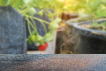 Empty wood table top and strawberry blur background.
